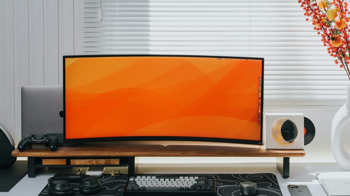 Monitor curvo sobre un escritorio con teclado y mouse