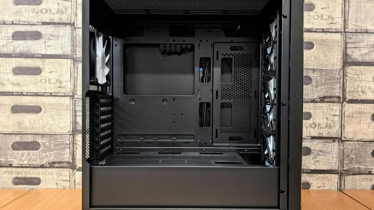 Gabinete de PC negro vacío sobre una mesa, con panel lateral abierto